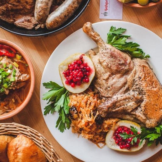 Утка с тушеной квашеной капустой, подается с яблоком, запеченным с брусникой